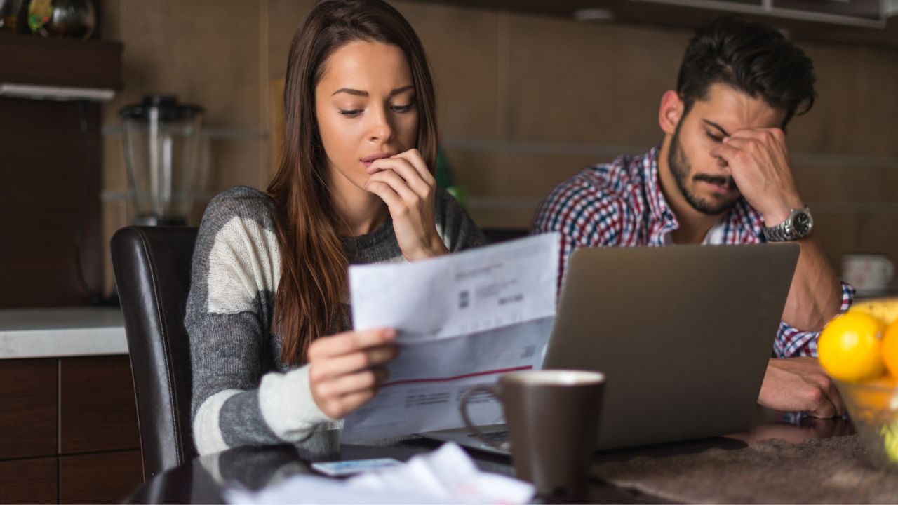 Concerned consumers reviewing a collection notice and financial records.